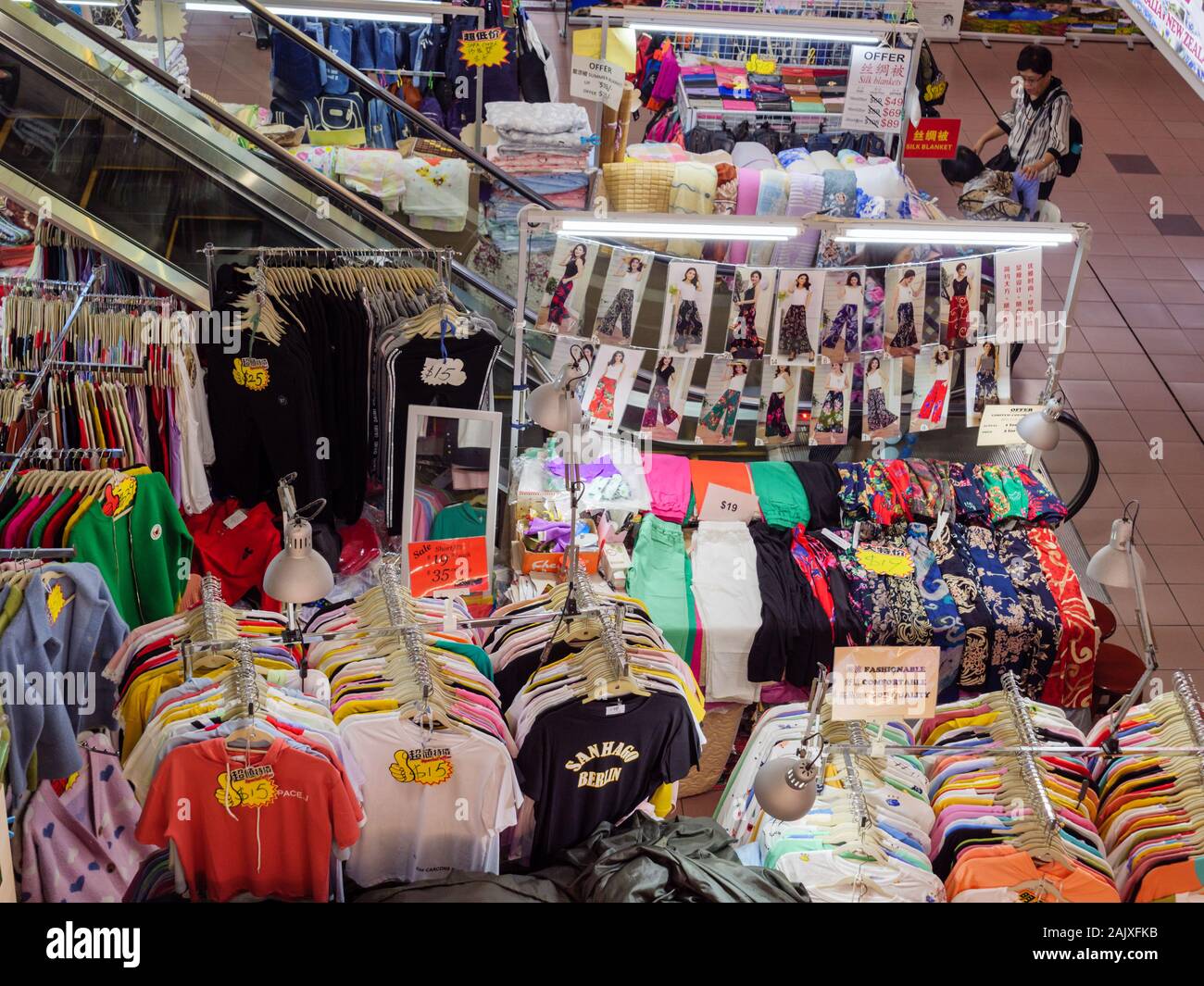 CHINATOWN, SINGAPORE – 26 DEC 2019 – Racks and piles of cheap discounted clothing for sale at the atrium of Peoples Park Complex mall in downtown Sing Stock Photo