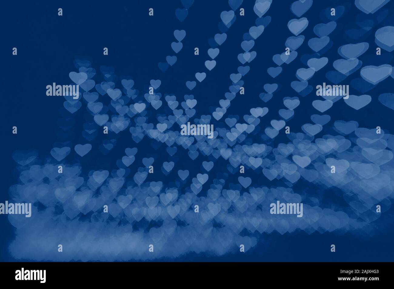 beautiful bokeh made of warm blue blurred lights in the form of hearts. Classic blue toning trend 2020 color Stock Photo