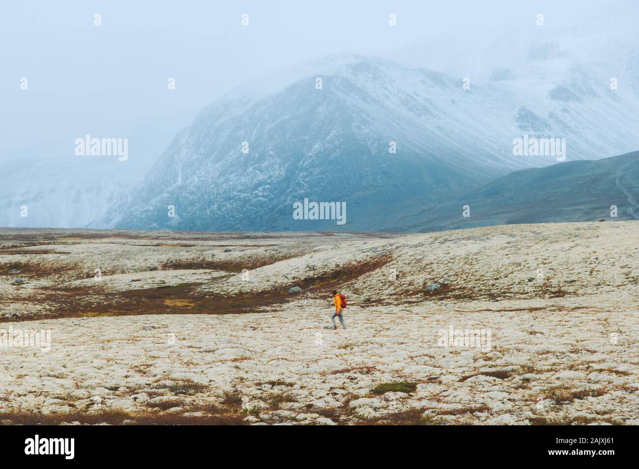 Man hiking in foggy mountains alone travel adventure survival in tundra active lifestyle vacations outdoor Rondane park landscape in Norway scandinavi Stock Photo