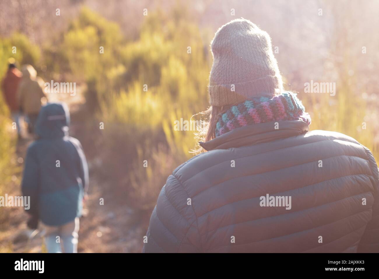 parent walking outdoors with 3 children Stock Photo