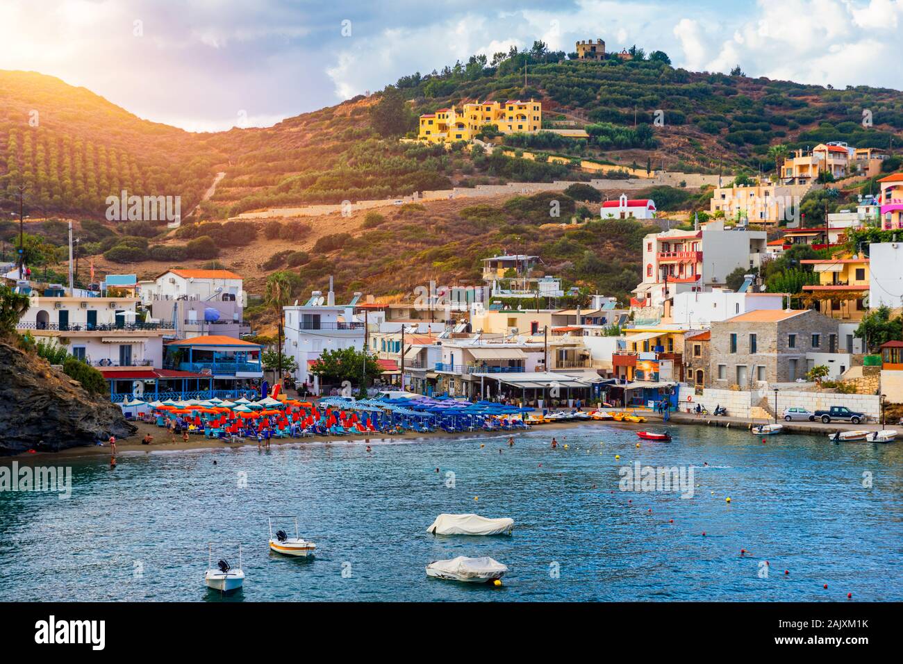 Panorama of Harbour with vessels, boats, beach and lighthouse in Bali at sunrise, Rethymno, Crete, Greece. Famous summer resort in Bali village, near Stock Photo