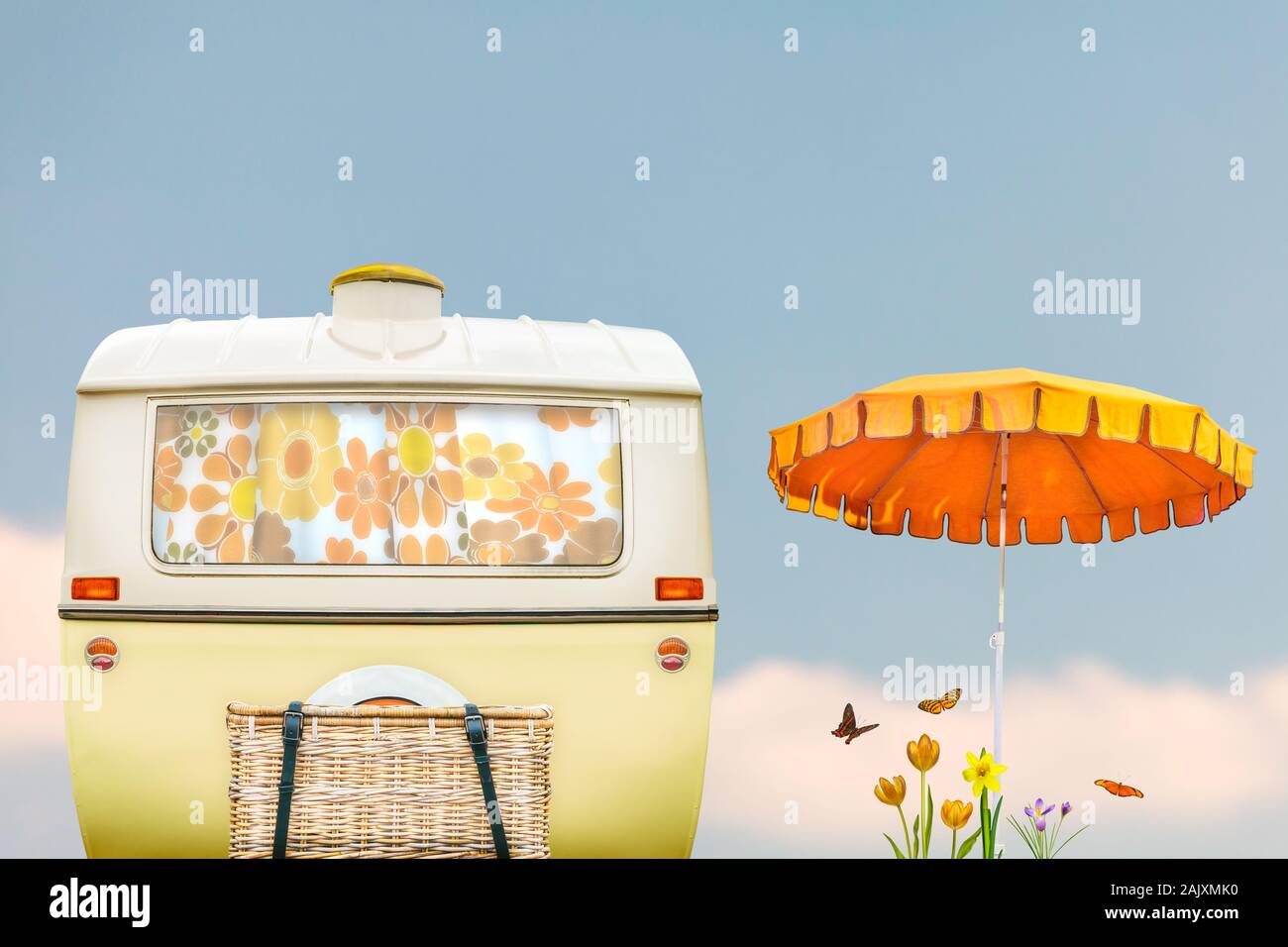 Vintage rear of a caravan in two tone yellow and white with parasol,  flowers and butterflies Stock Photo - Alamy