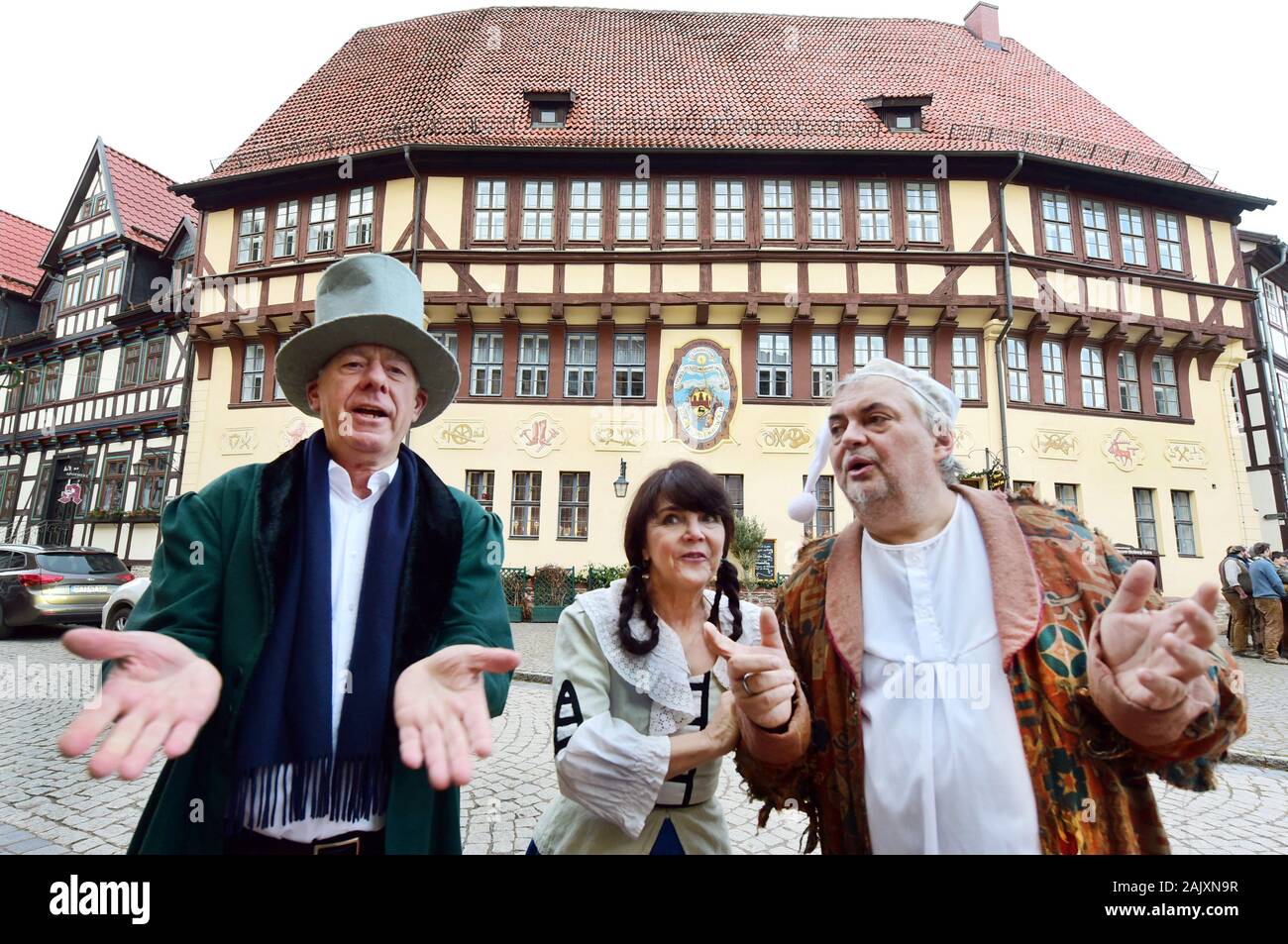 03 January 2020, Saxony-Anhalt, Stolberg: In front of the over 550-year-old town hall in the Harz half-timbered town of Stolberg, known as the 'curiosity of architecture', are the actors Mario (r) and Christiane Jantosch (M) from the AllerweltTheatre with the local mayor Ulrich Franke (l) as teacher Lämpel, widow Bolte and tailor Böck from the Wilhelm Busch Theatre programme. Together with the approximately 1,100 inhabitants of Stolberg, the three are delighted to have won first place in the competition for the title 'Germany's most beautiful village'. Announced by the online travel magazine T Stock Photo