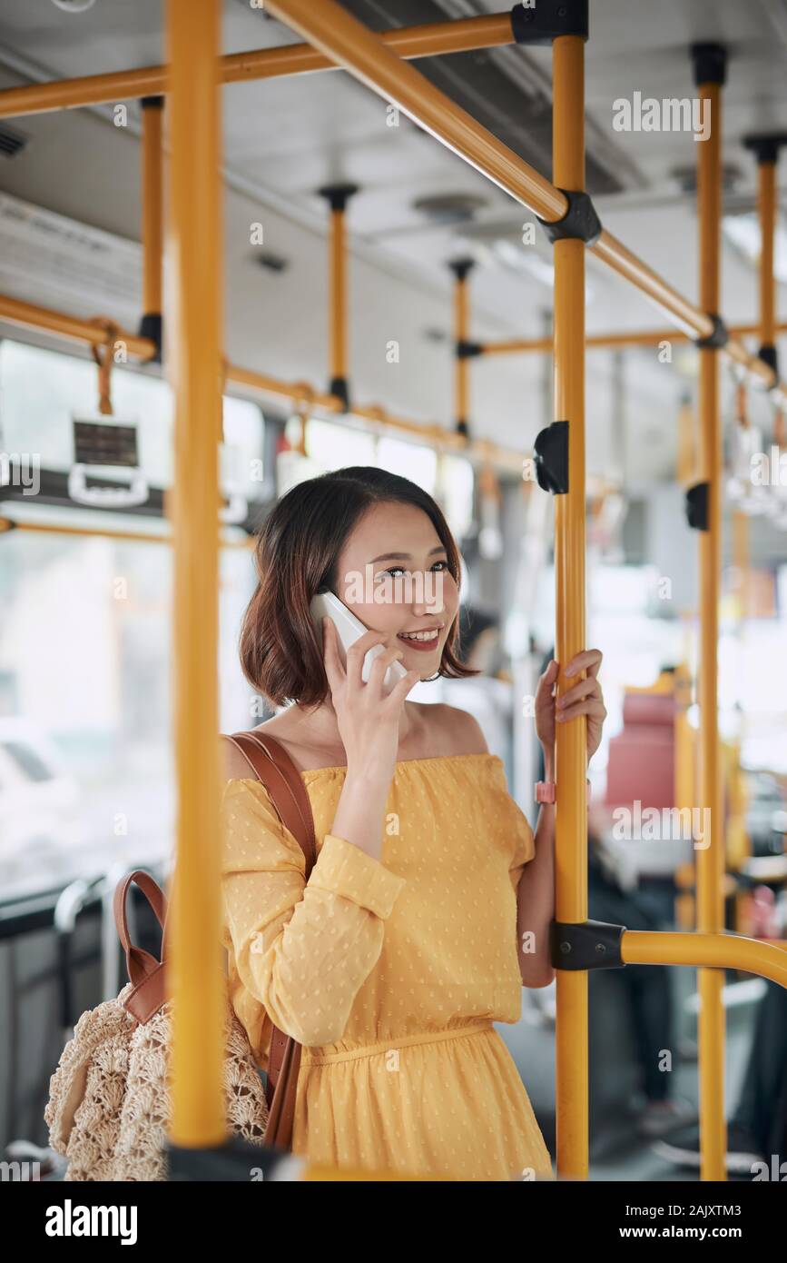 Asian girl using phone on public bus Stock Photo