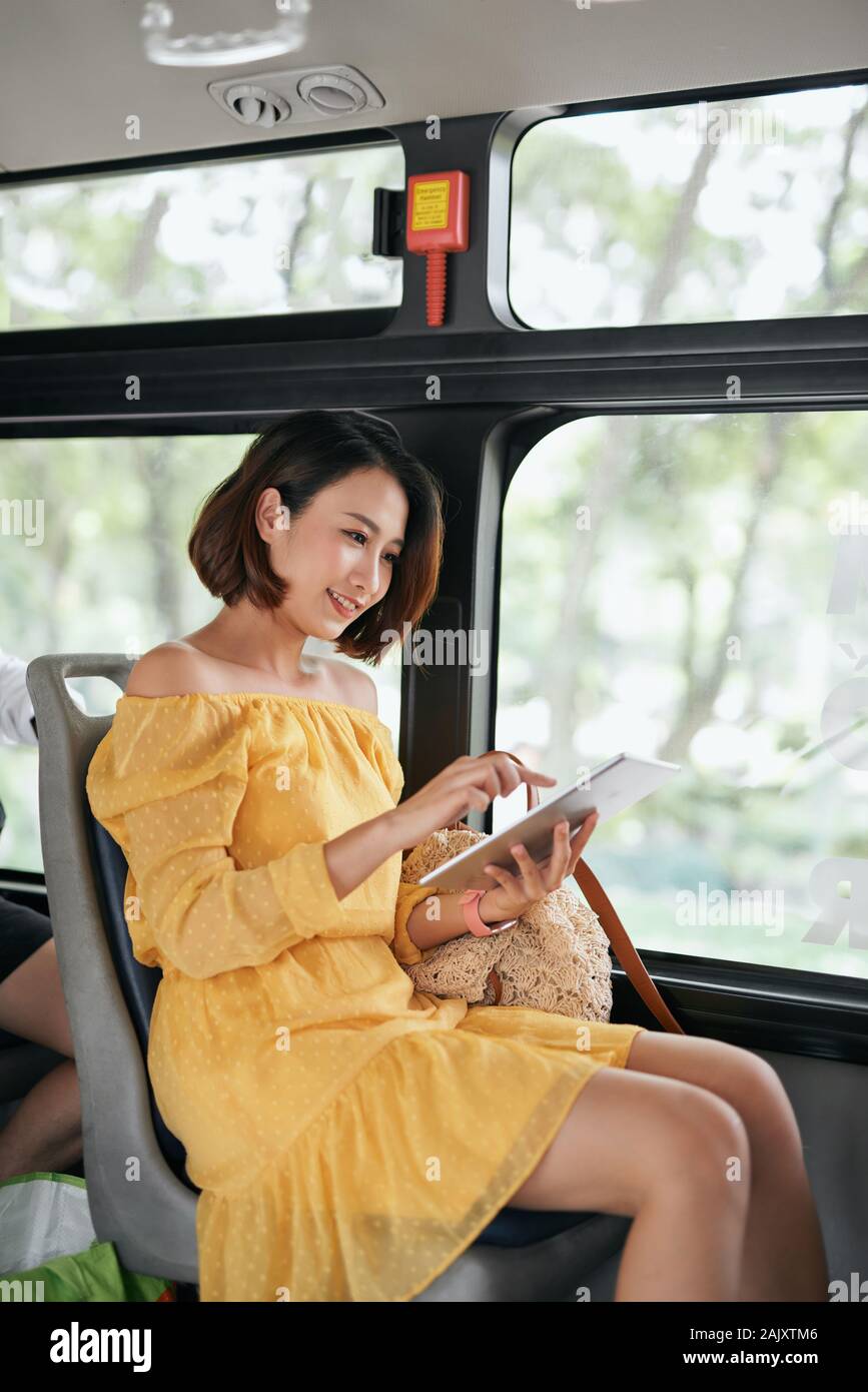 Young woman using tablet computer on the bus Stock Photo