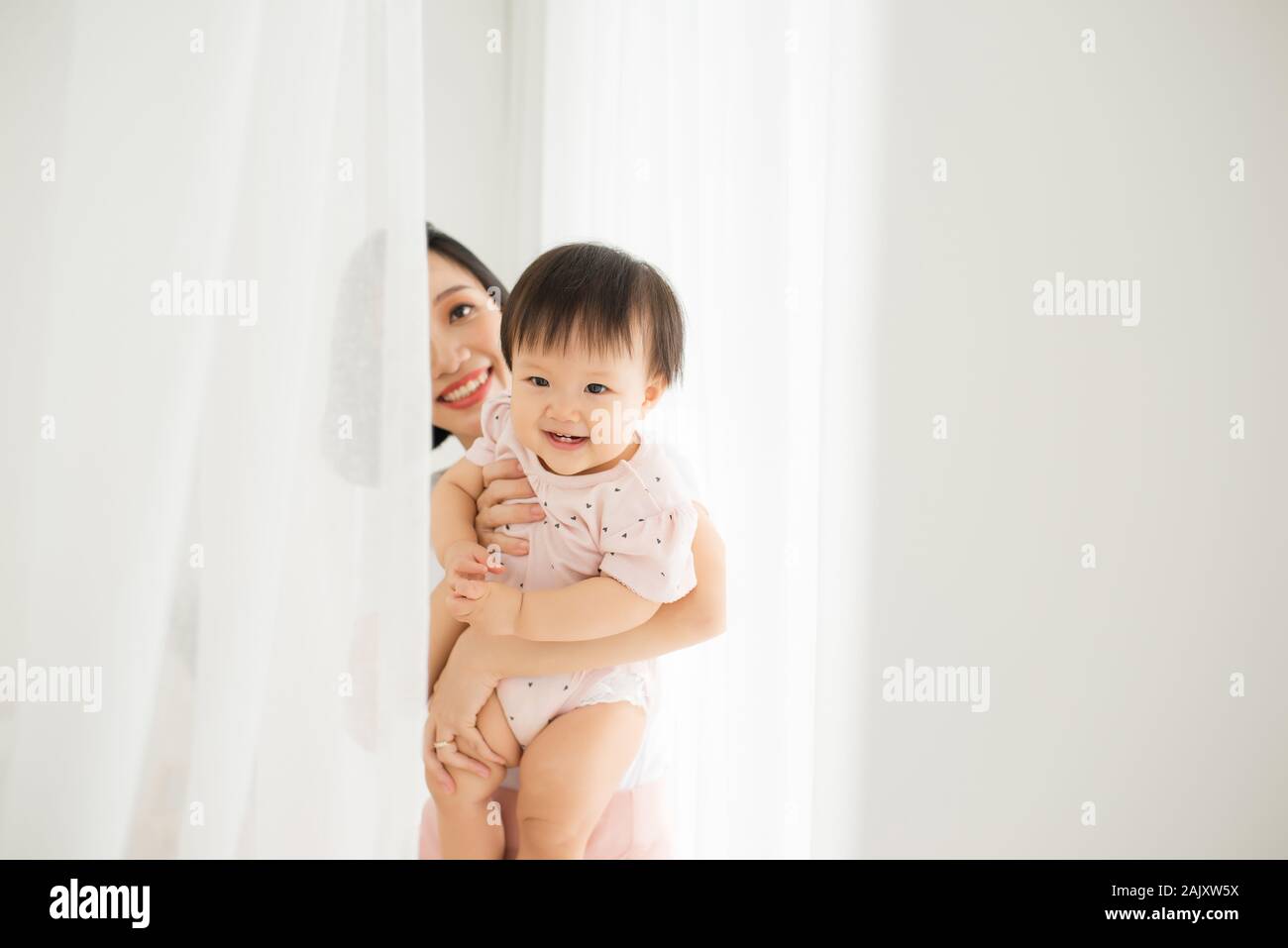 Mom and her daughter child girl are playing, smiling and hugging. Family holiday and togetherness. Stock Photo