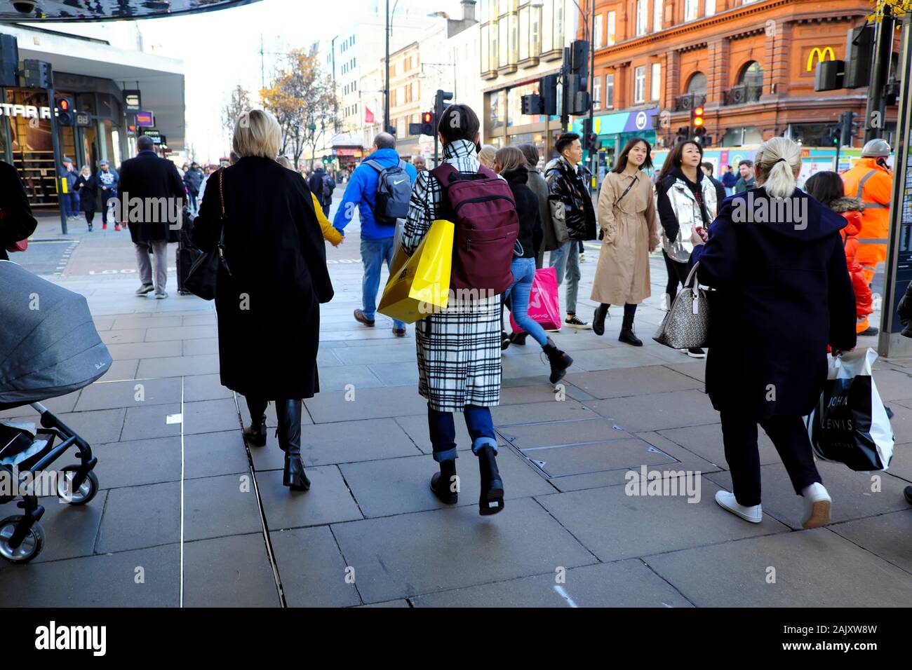 Rear view of people woman with shopping bag outside high street stores ...
