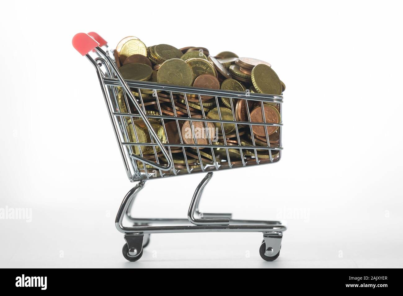 Side View of Tiny Shopping Trolley Full of Euro Coins on White Stock Photo