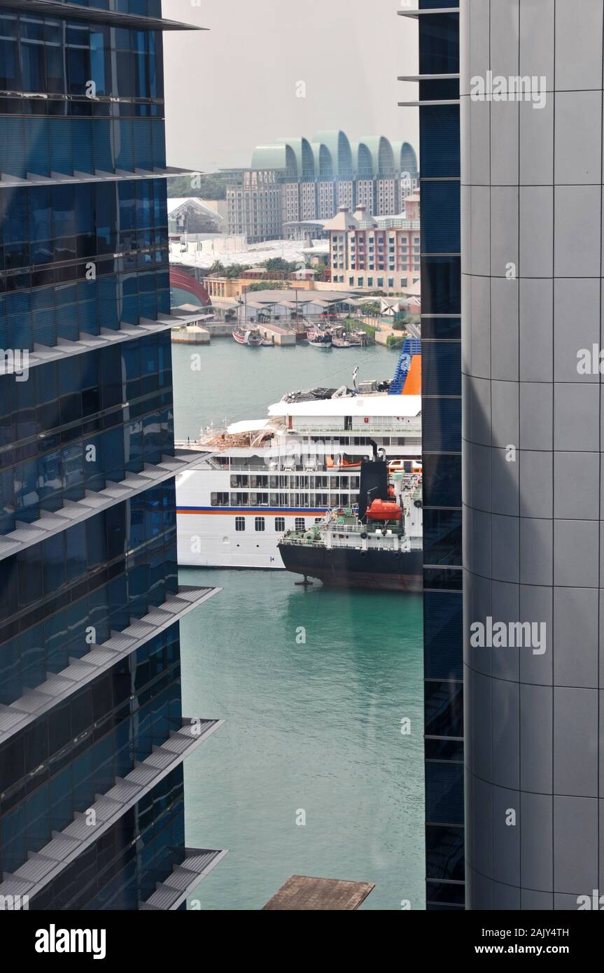 Around Singapore - view through building of a cruise ship in the harbour Stock Photo