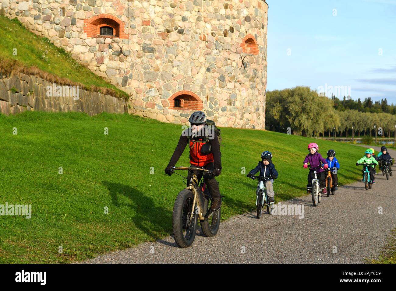 Little kids with his teacher on bicycles. Hameenlinna, Suomi Stock Photo