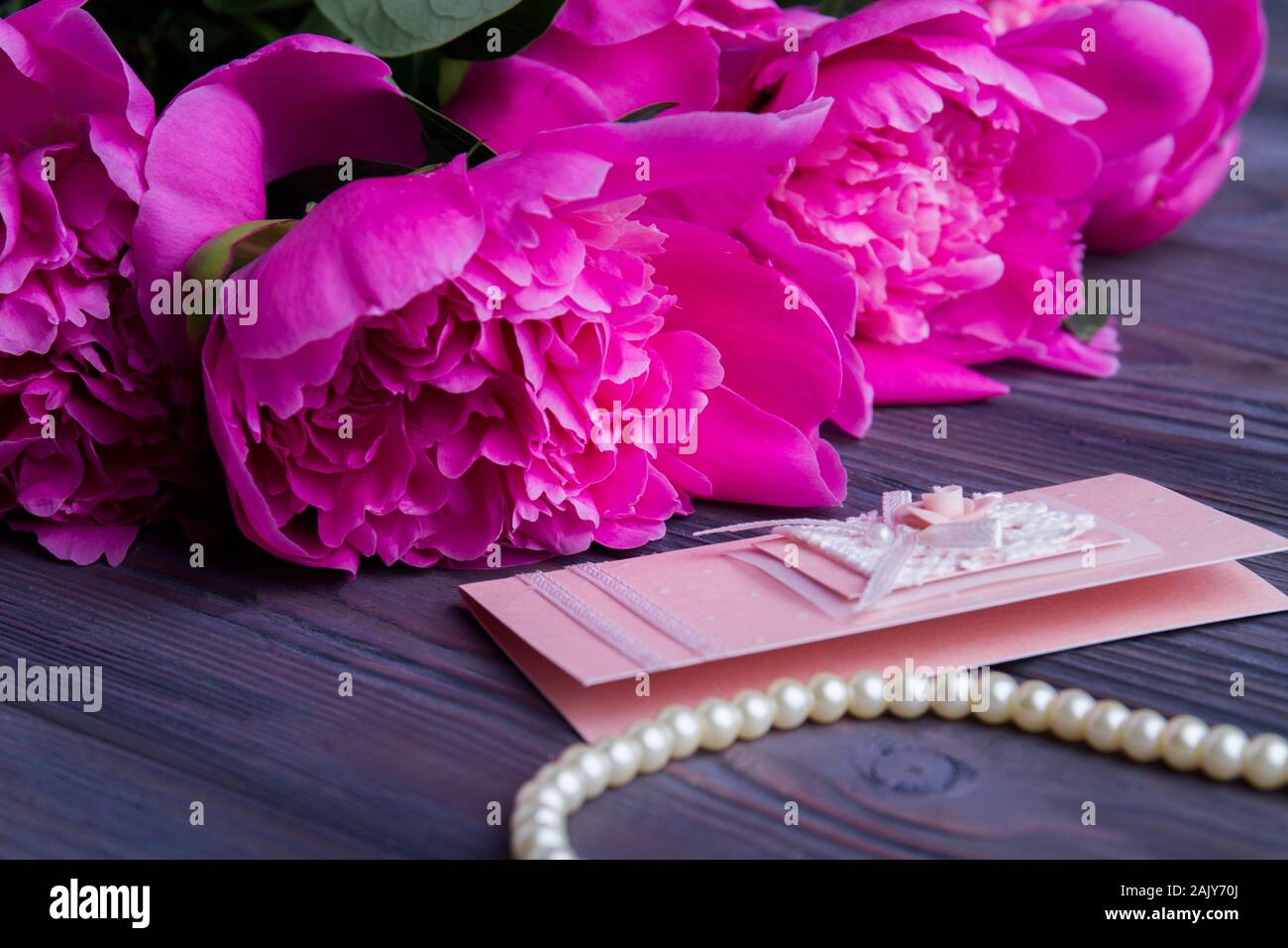 Pink peonies, postcard and pearl necklace Stock Photo Alamy
