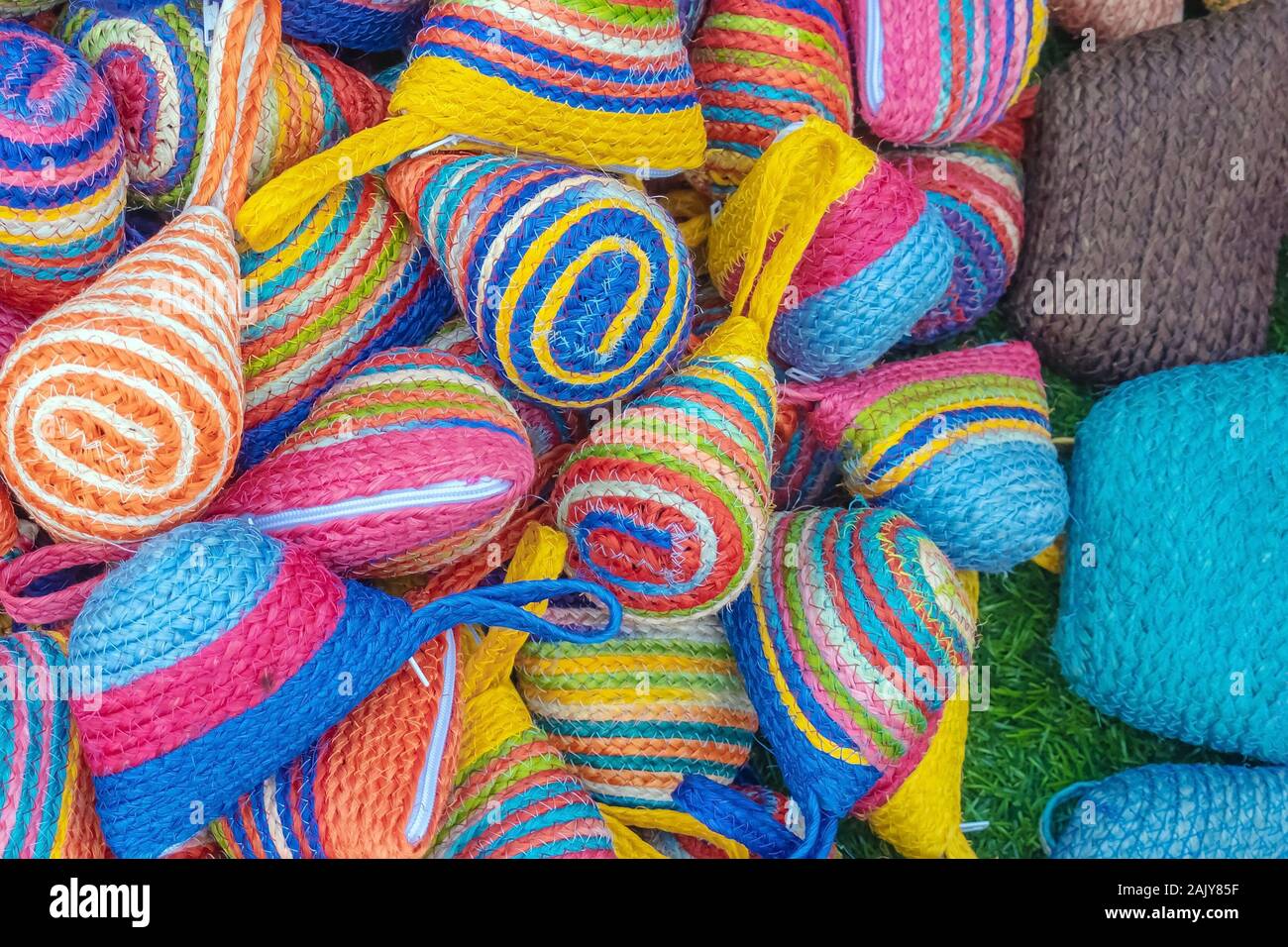 Close up to vintage handicraft colorful bags by yarn for sale at local market in Thailand. Selective focus. Stock Photo