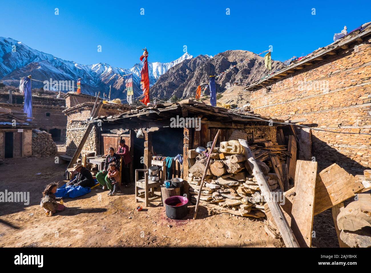 A family outside the traditional buildings in the Tibetan village of Ringmo near Phoksundo in the Dolpo region of the Nepal Himalayas Stock Photo