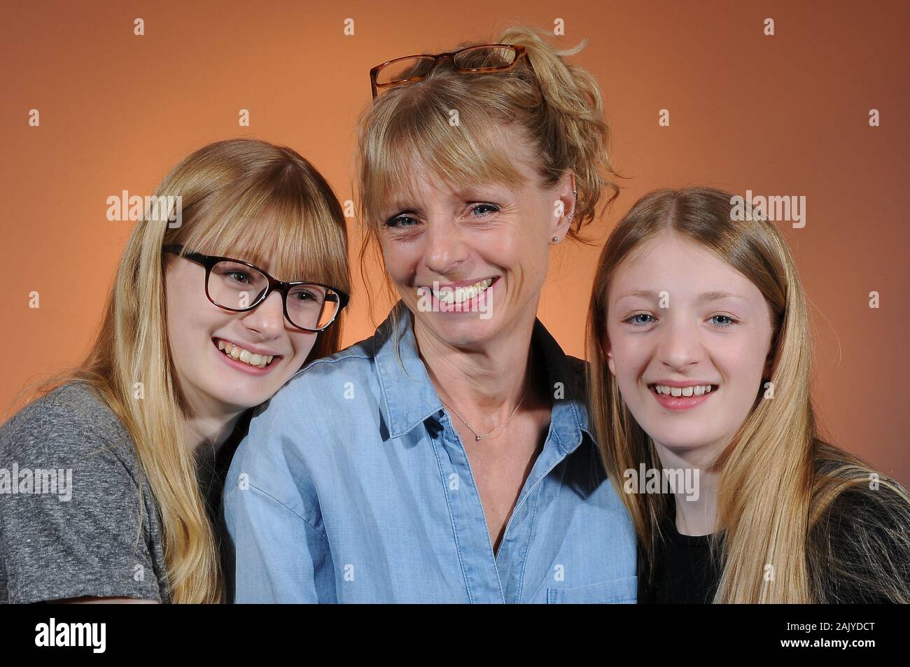 pretty blonde woman and her two pretty blonde teenage daughters on a graduated background Stock Photo