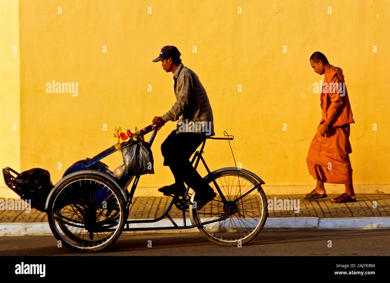 Monk walking to the monastery in the morning, passed by a cyclo Stock Photo
