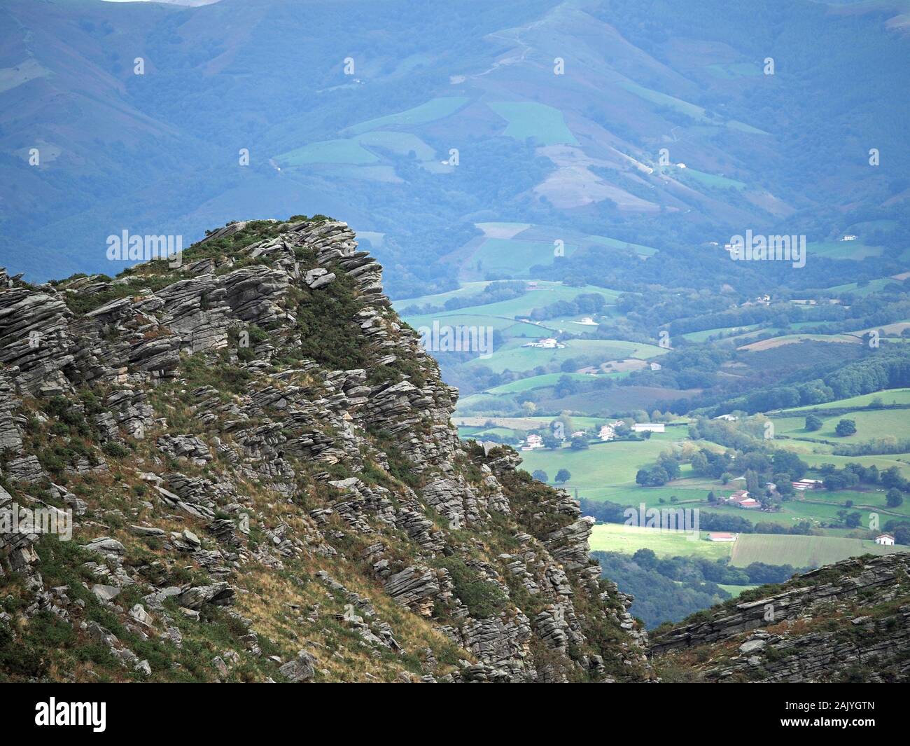 rocky crags dominating hilltop view across the Western Pyrenees from cog railway up La Rhune mountain, Pyrenees, France Stock Photo