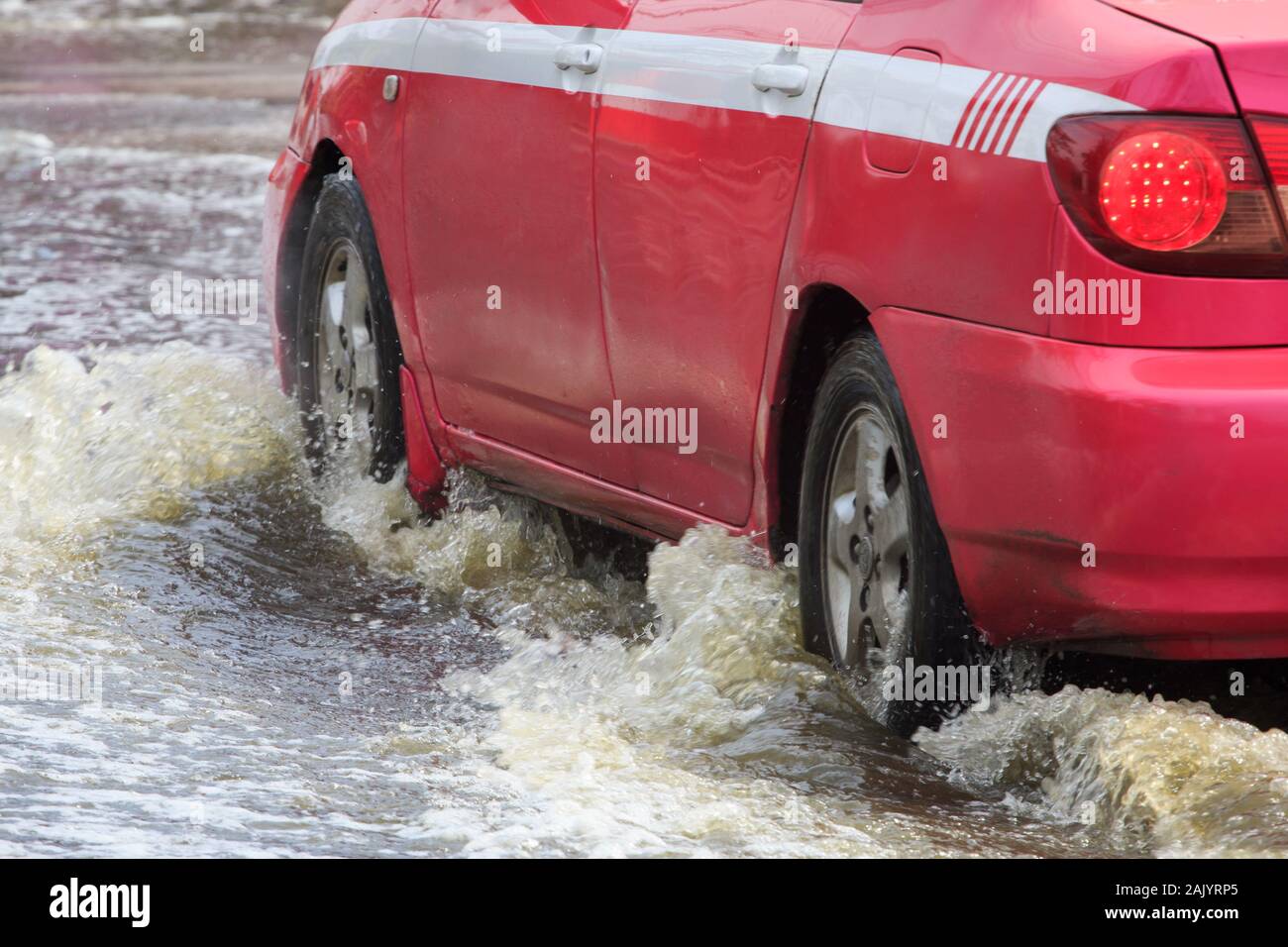 Car splashes through a large puddle on a flooded street Stock Photo Alamy