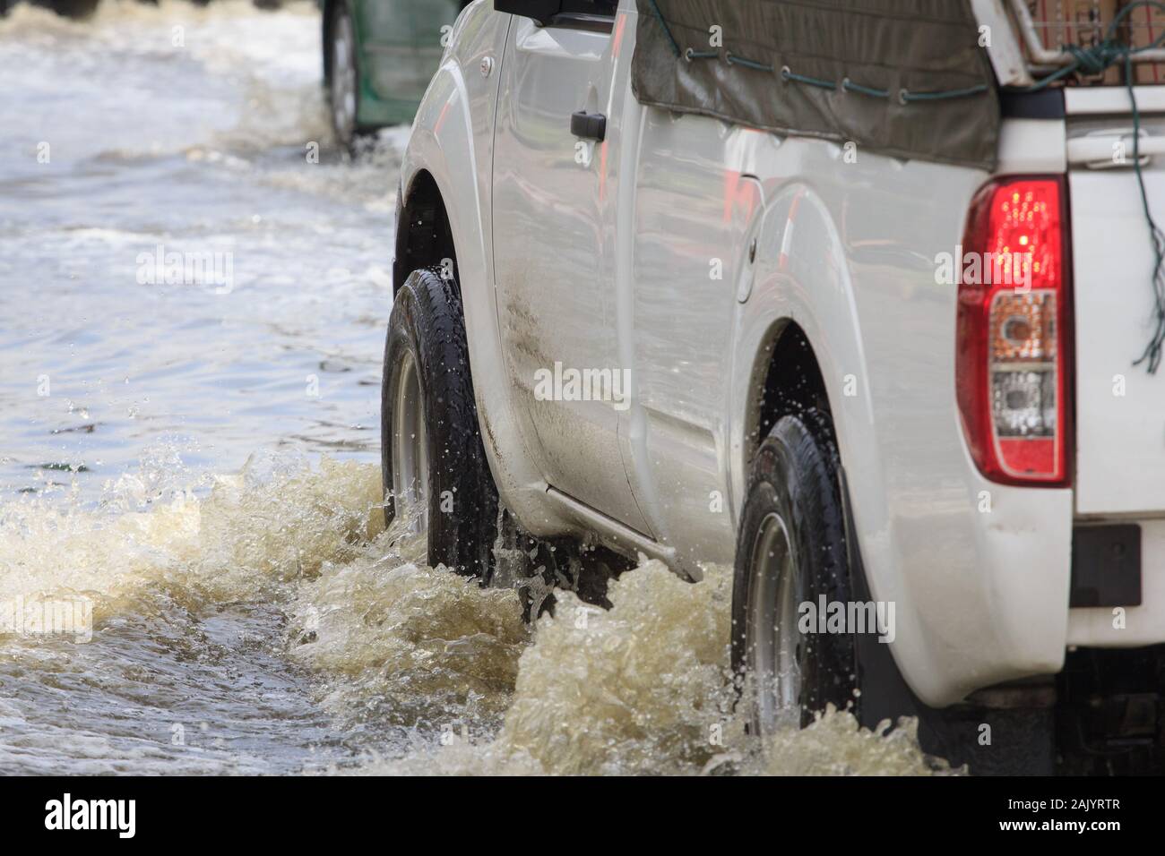 Car splashes through a large puddle on a flooded street Stock Photo Alamy
