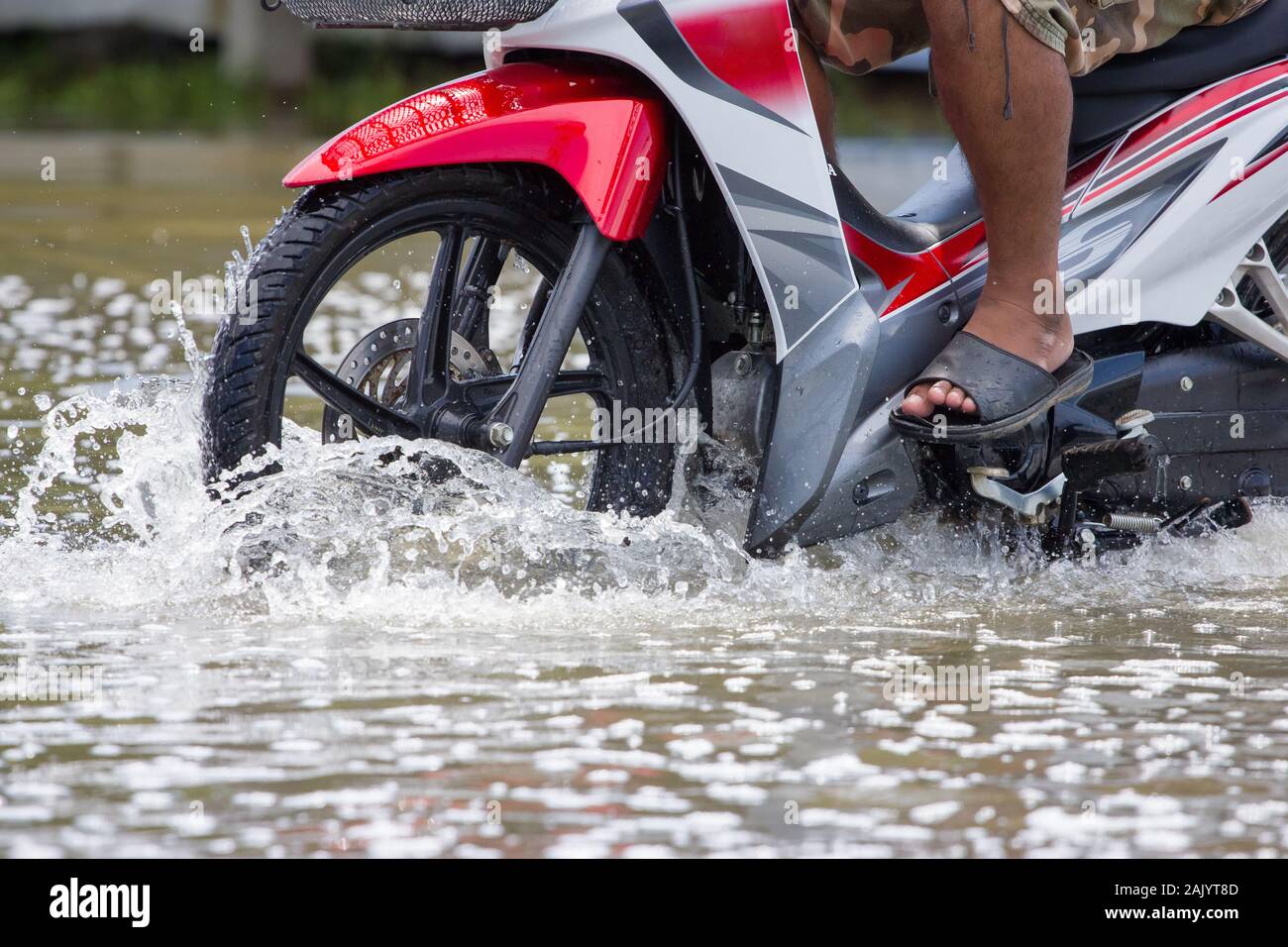 Splash by a motorcycle as it goes through flood water Stock Photo