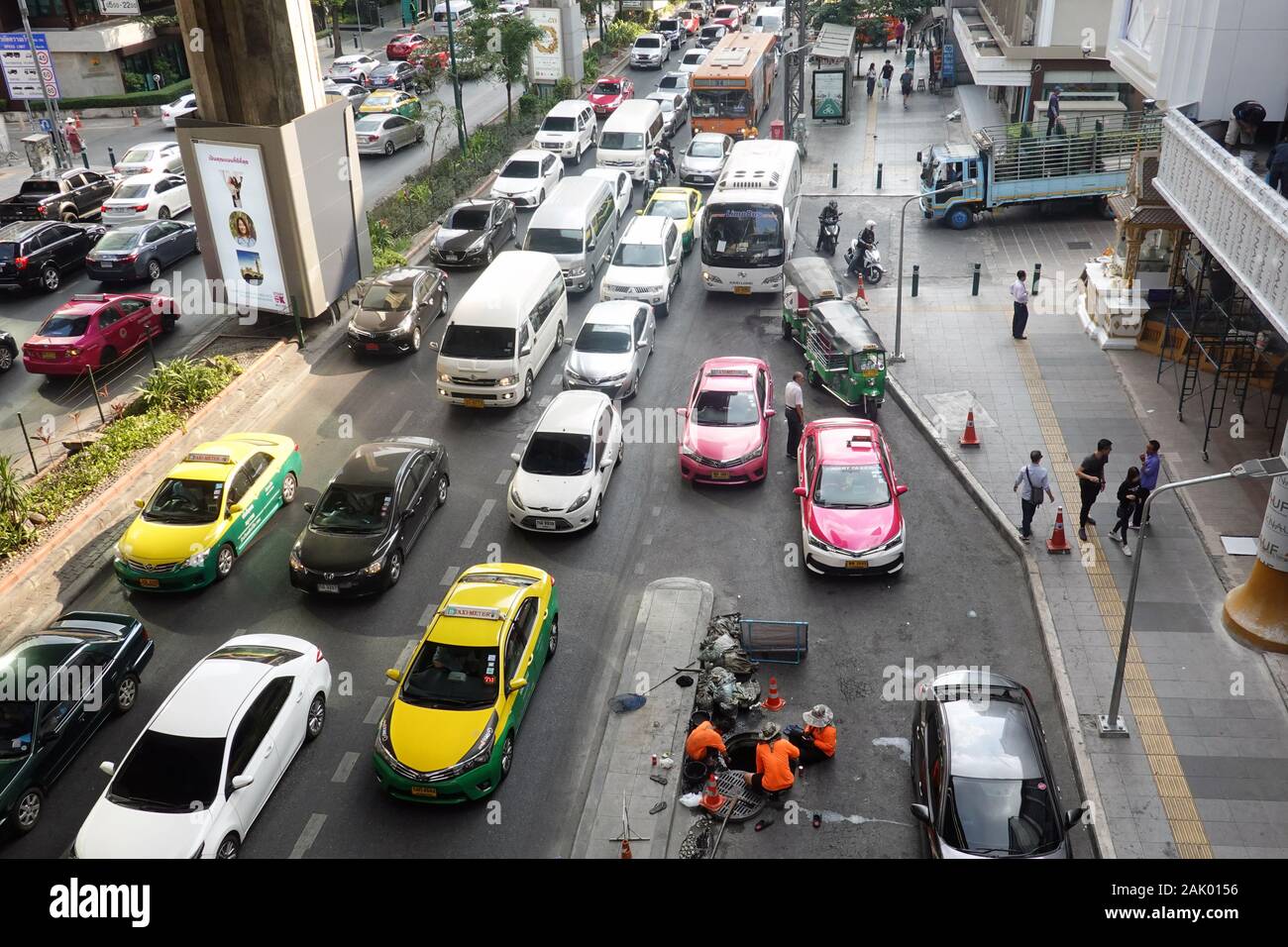 Bangkok, Thailand - December 21, 2019: Traffic jam and workers cleaning sewer. Stock Photo