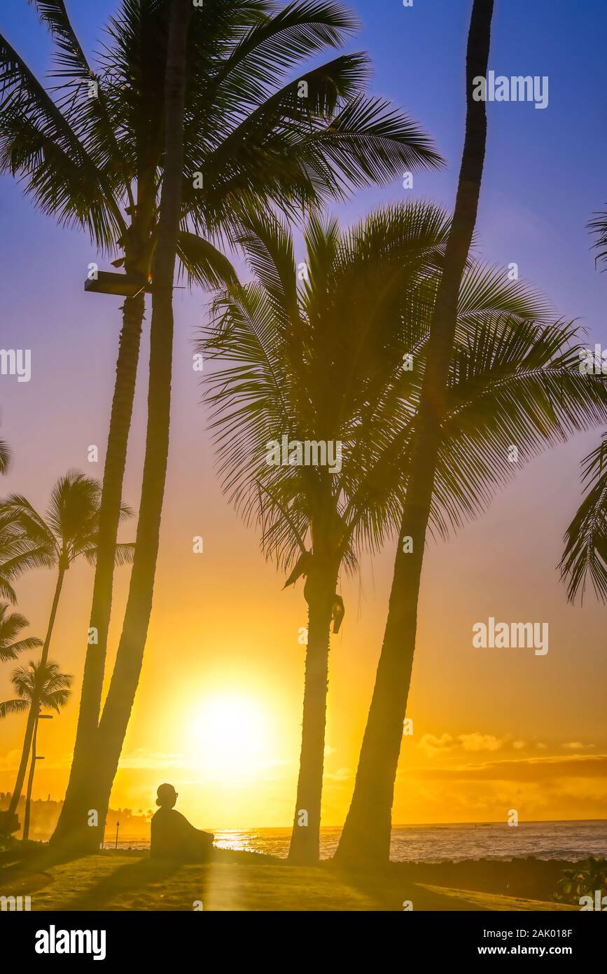 A silhouette watches the sunrise on Kauai, Hawaii. Stock Photo