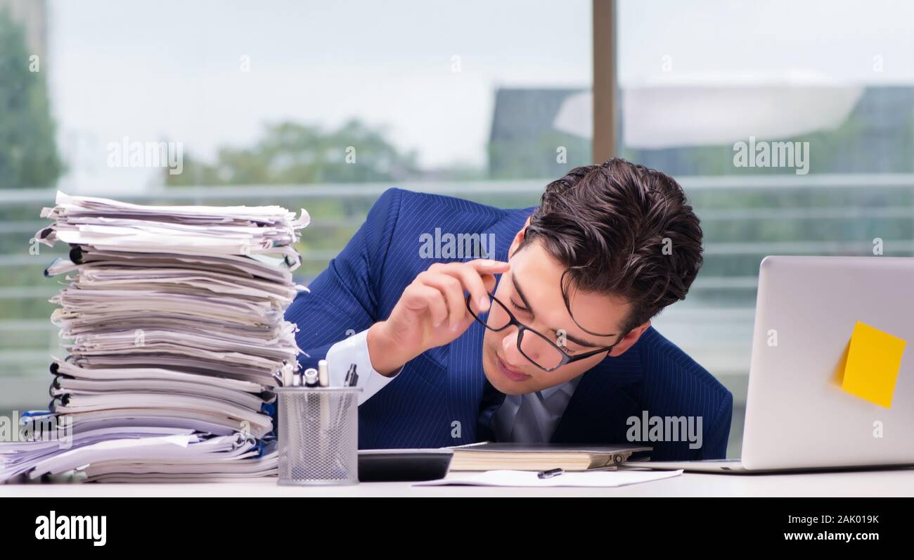 The workaholic businessman overworked with too much work in office ...