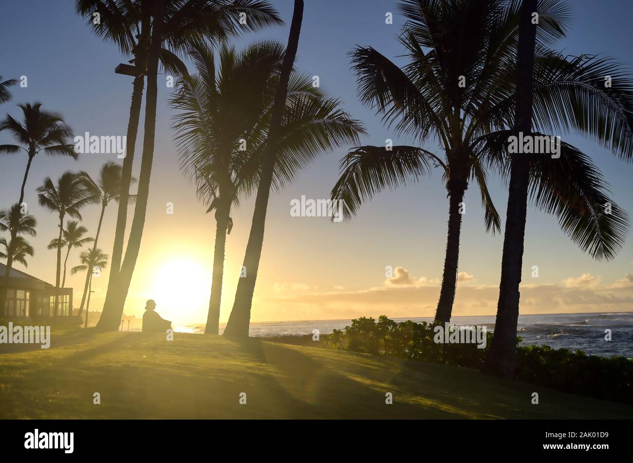 A silhouette watches the sunrise on Kauai, Hawaii. Stock Photo