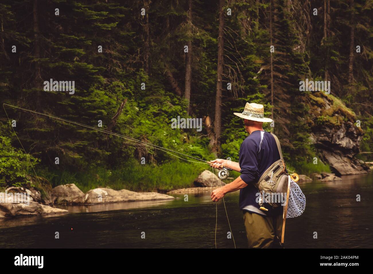 A fly fisherman fishing for wild trout on the mountain river in the