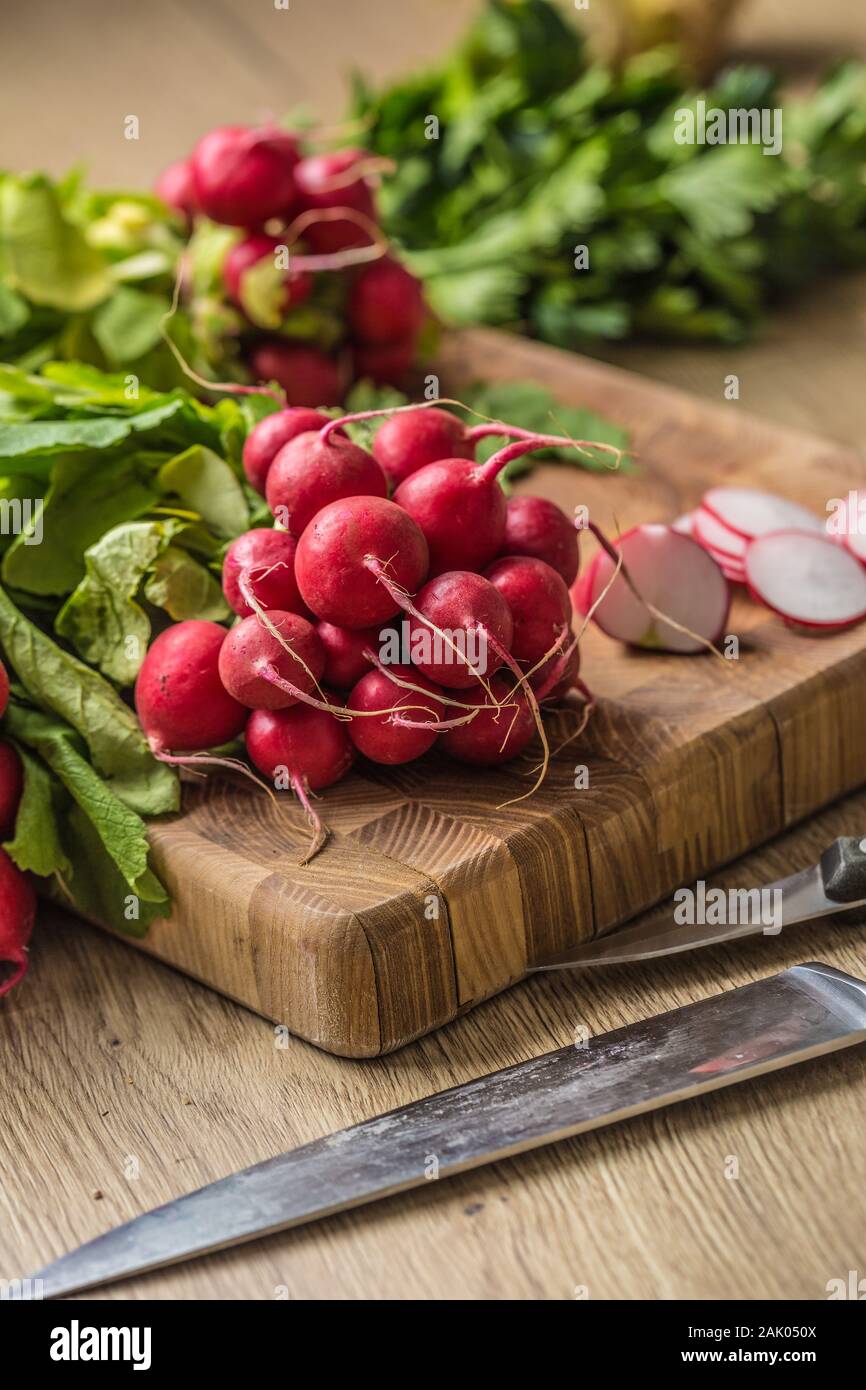 Fresh bundles of radish laid on a kitchen table Stock Photo