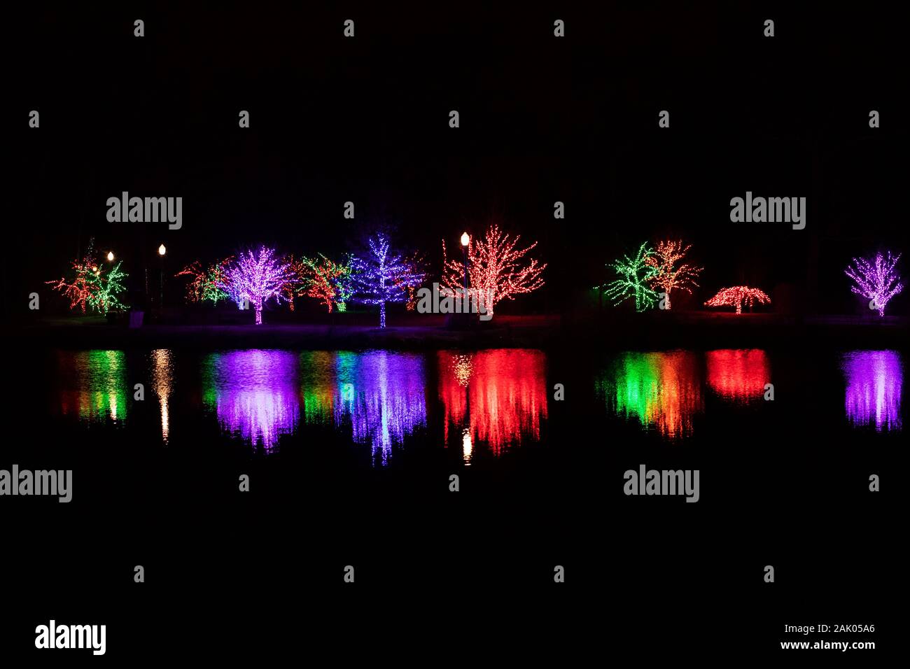 Christmas lights reflecting in the lake at Winter Wonderland Holiday Lights at Wellfield Botanic Gardens in Elkhart, Indiana, USA. Stock Photo