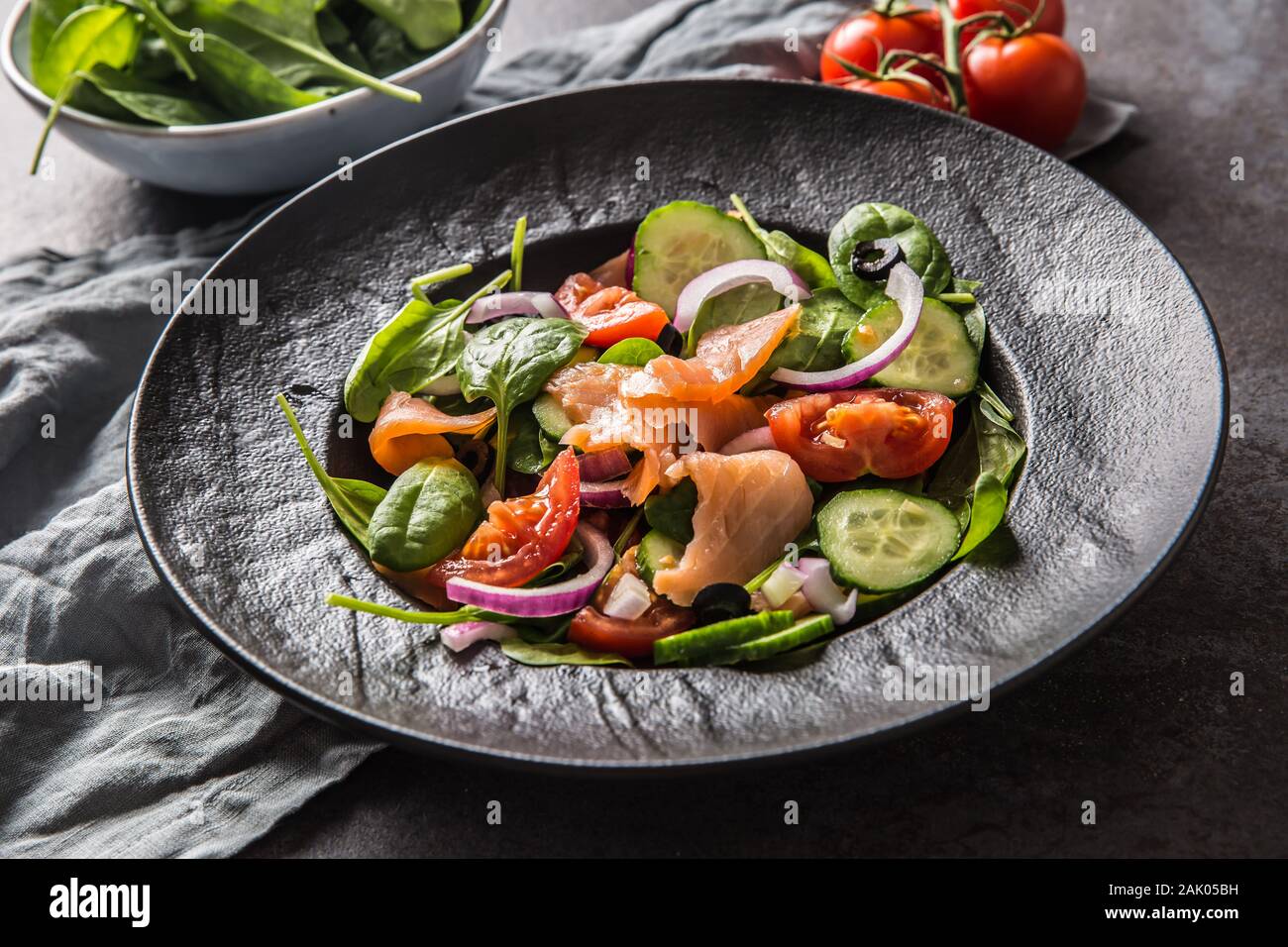 Salmon salad with vegetable in plate on dark kitchen table Stock Photo
