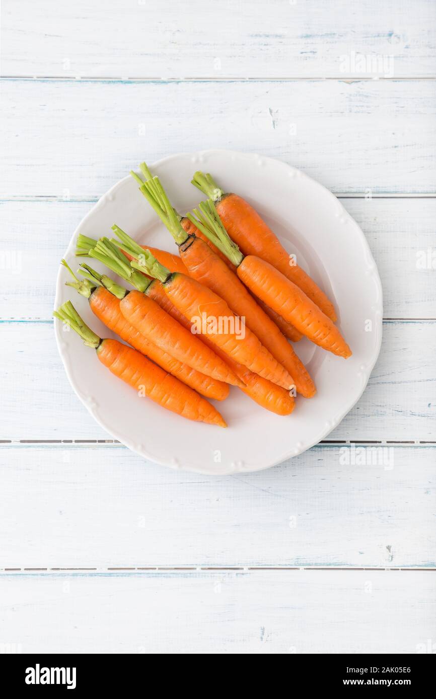 Fresh carrot on white plate on table - Top of view Stock Photo