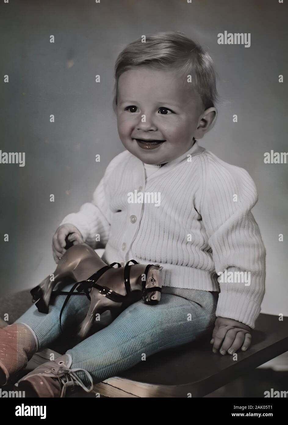 Kind, Junge mit ca 3 Jahren, mit einem Holzpferd Spielzeug, lacht freundlich und zufrieden / Child, boy around 3 years old, with a wooden horse toy, laughs friendly and contentedly, Digitale Reproduktion von einer Originalvorlage aus dem 19. Jahrhundert / digital improved reproduction of an original print from the 19th century Stock Photo