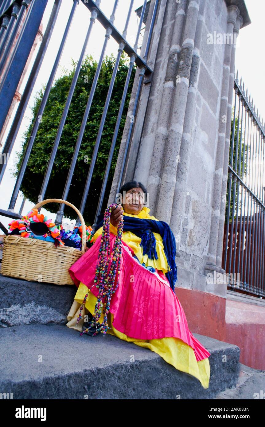 Street vendor selling souveniers to tourists in front of La Parroquia church, San Miguel de Allende, Mexico Stock Photo