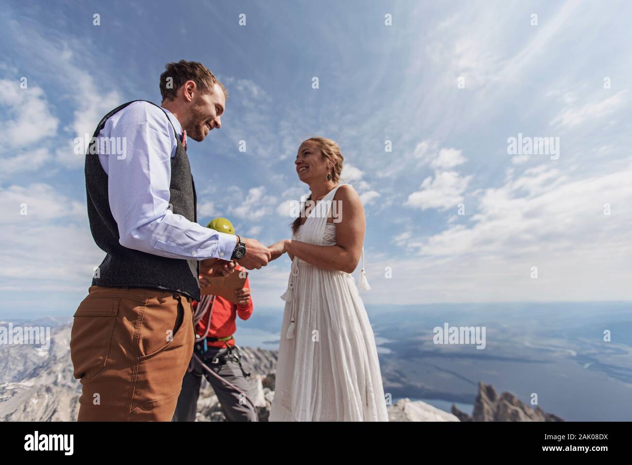 Couple exchanges vows and rings during wedding on top of mountain Stock Photo