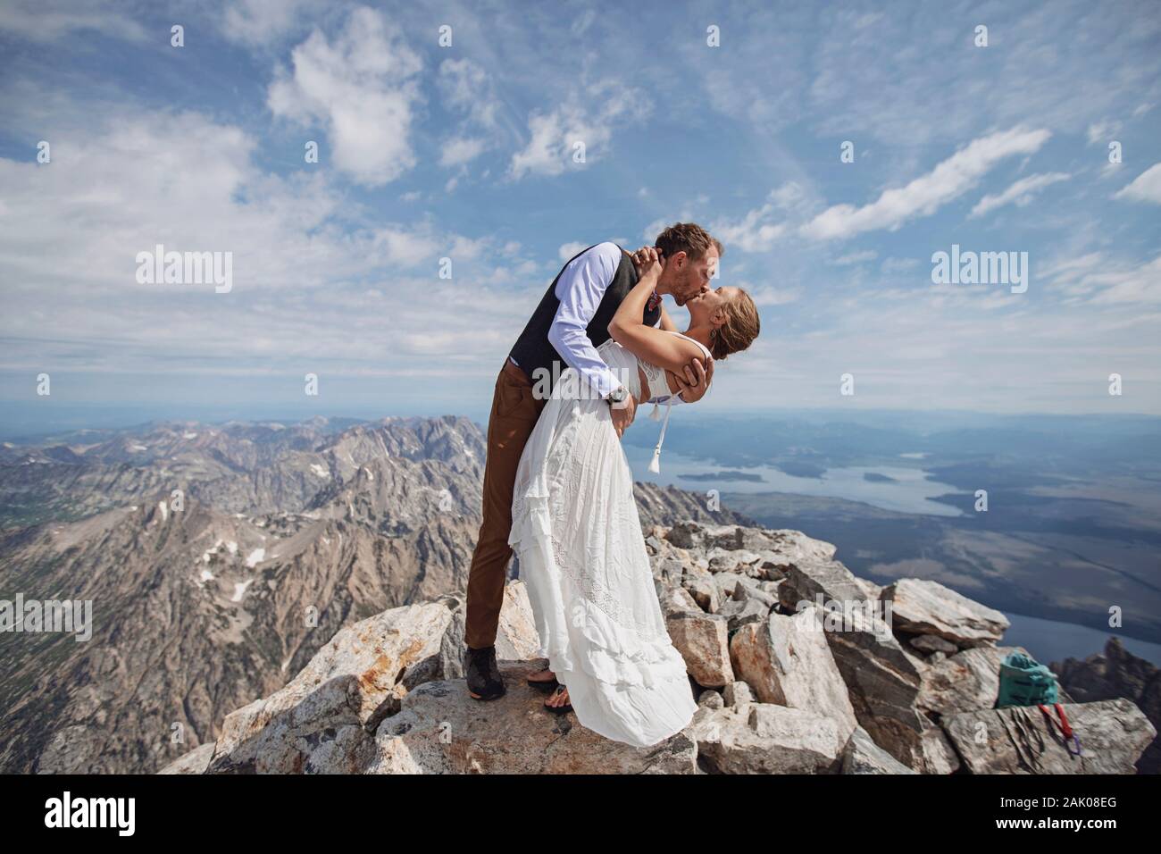 Groom dips bride after getting married on summit of mountain Stock Photo