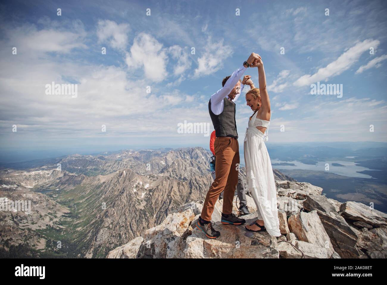 Bride and Groom celebrate after getting married on summit of mountain Stock Photo