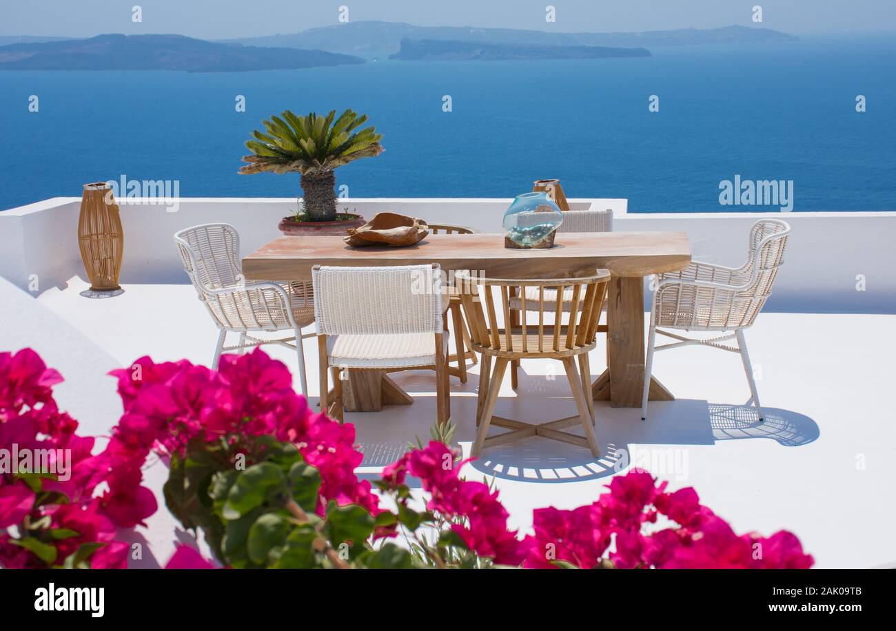 furniture composed by a table and some chairs on a white floral terrace