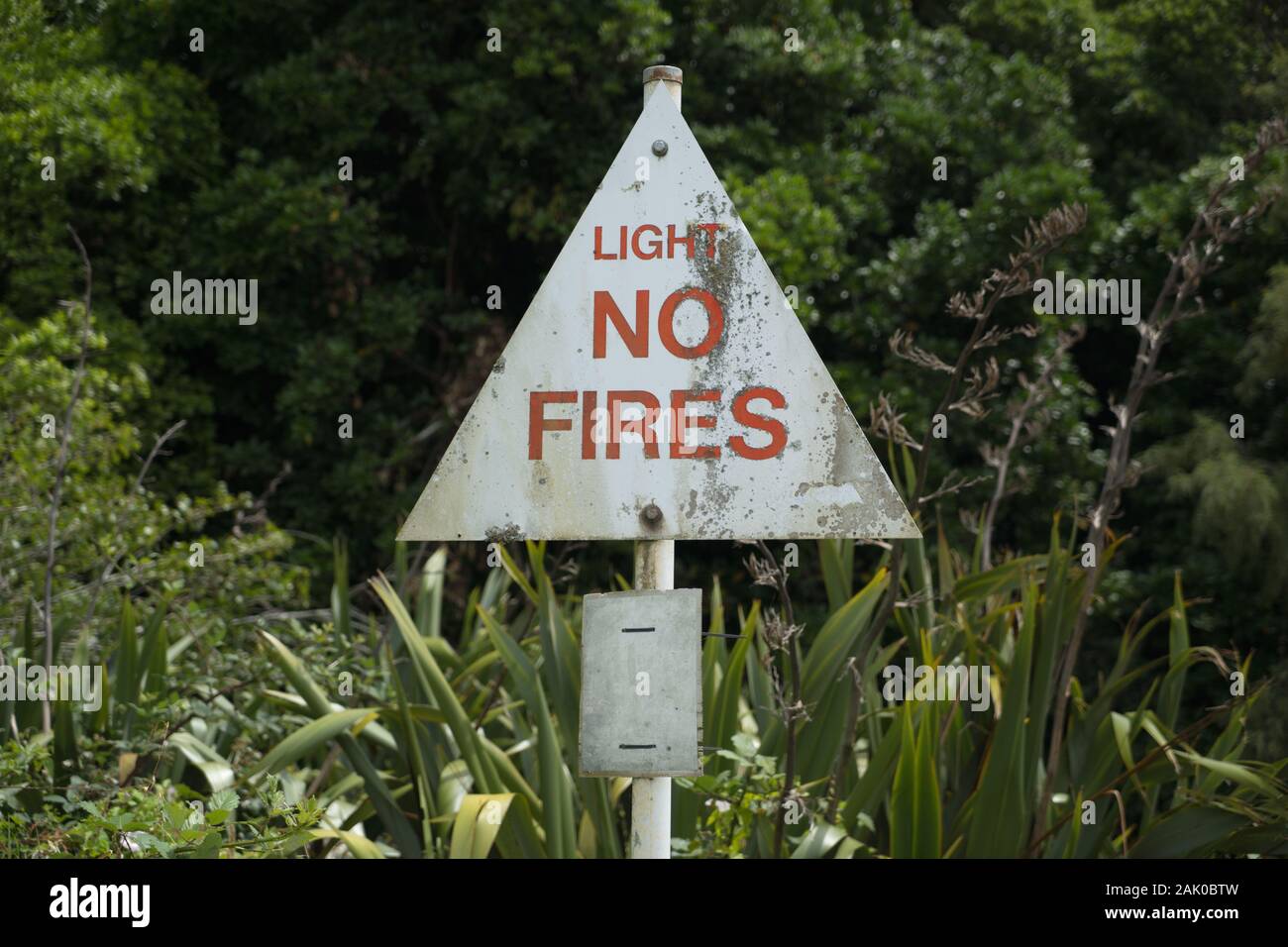 Three sisters car park, Tongoporutu, Northern Taranaki,  New Zealand. A weathered white and red Light No Fires warning sign forest, bush, fire season Stock Photo