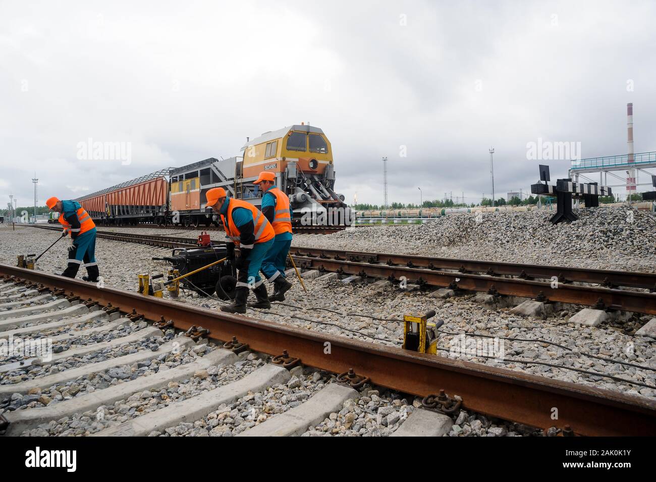 Railway workers repairing rail in rain Stock Photo
