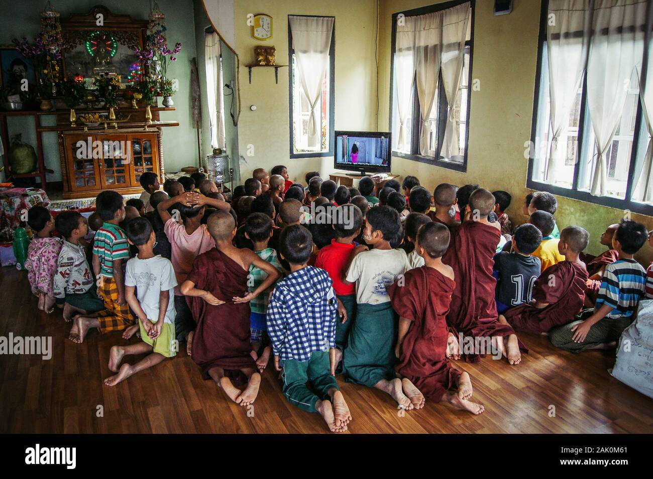 orphan asian children watching tv Stock Photo