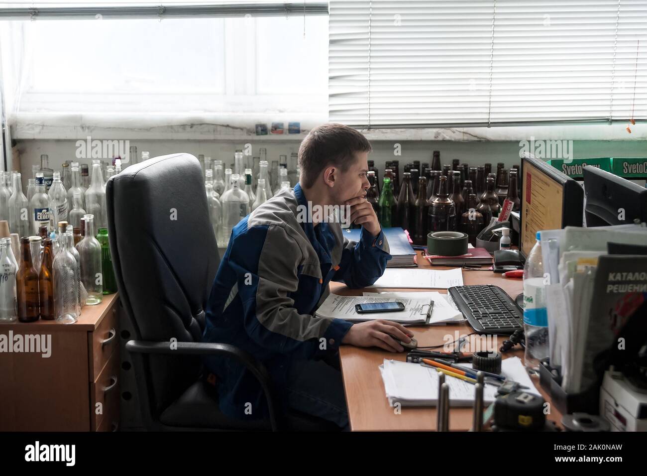 Engineer works on PC in bottle factory. Tyumen Stock Photo