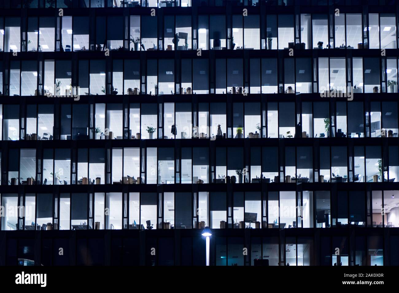 Office Building At Night. Late night at work. Glass curtain wall office  building. Office building exterior in the late evening with interior lights  on Stock Photo - Alamy
