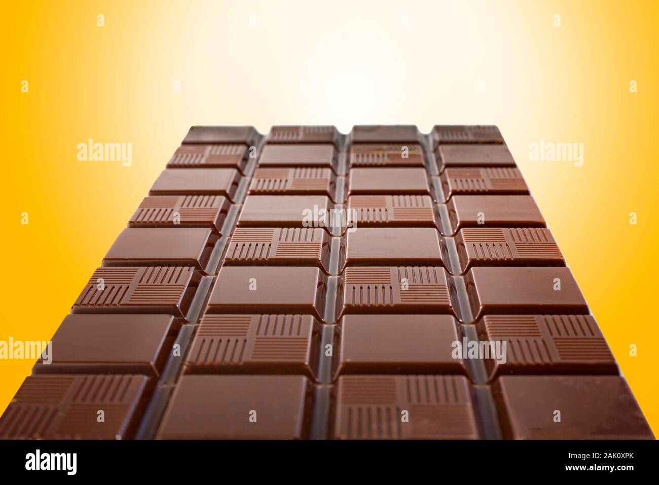 chocolate bar taken in perspective with a glittering golden and shiny background Stock Photo