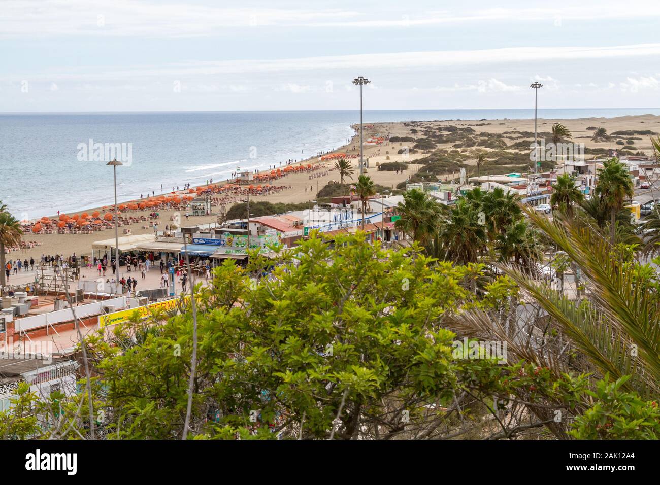 View over the Playa del Ingles beach area near the dunes in Maspalomas, Gran Canaria with beach chairs and restaurants visible Stock Photo