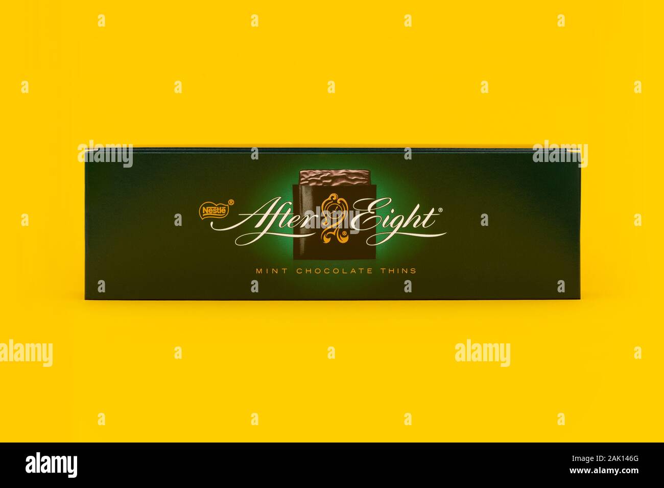 A box of Nestle After Eight chocolates shot on a yellow background. Stock Photo