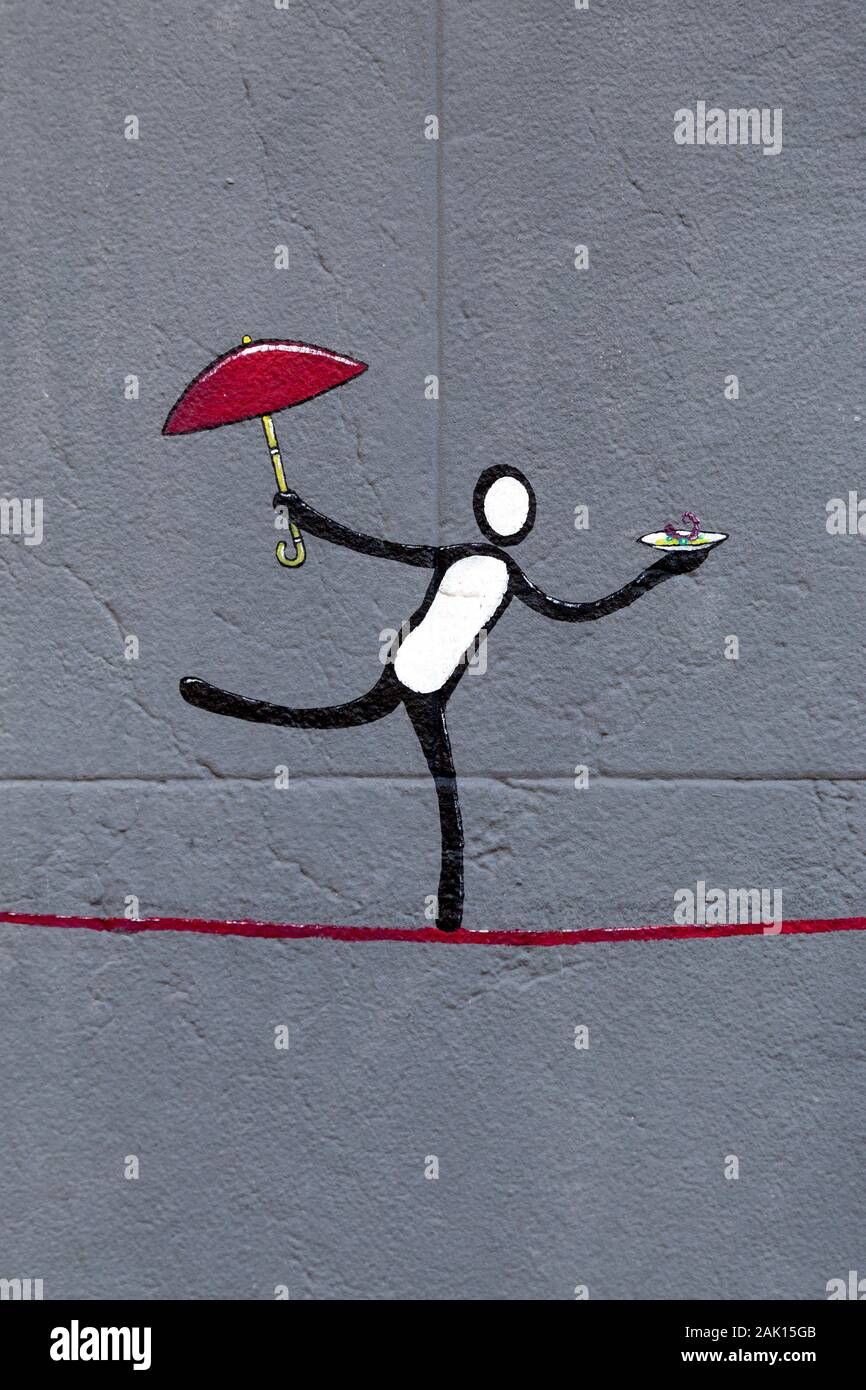 Street art of a figure balancing on a line, holding umbrella and dish, Palma, Mallorca, Spain Stock Photo