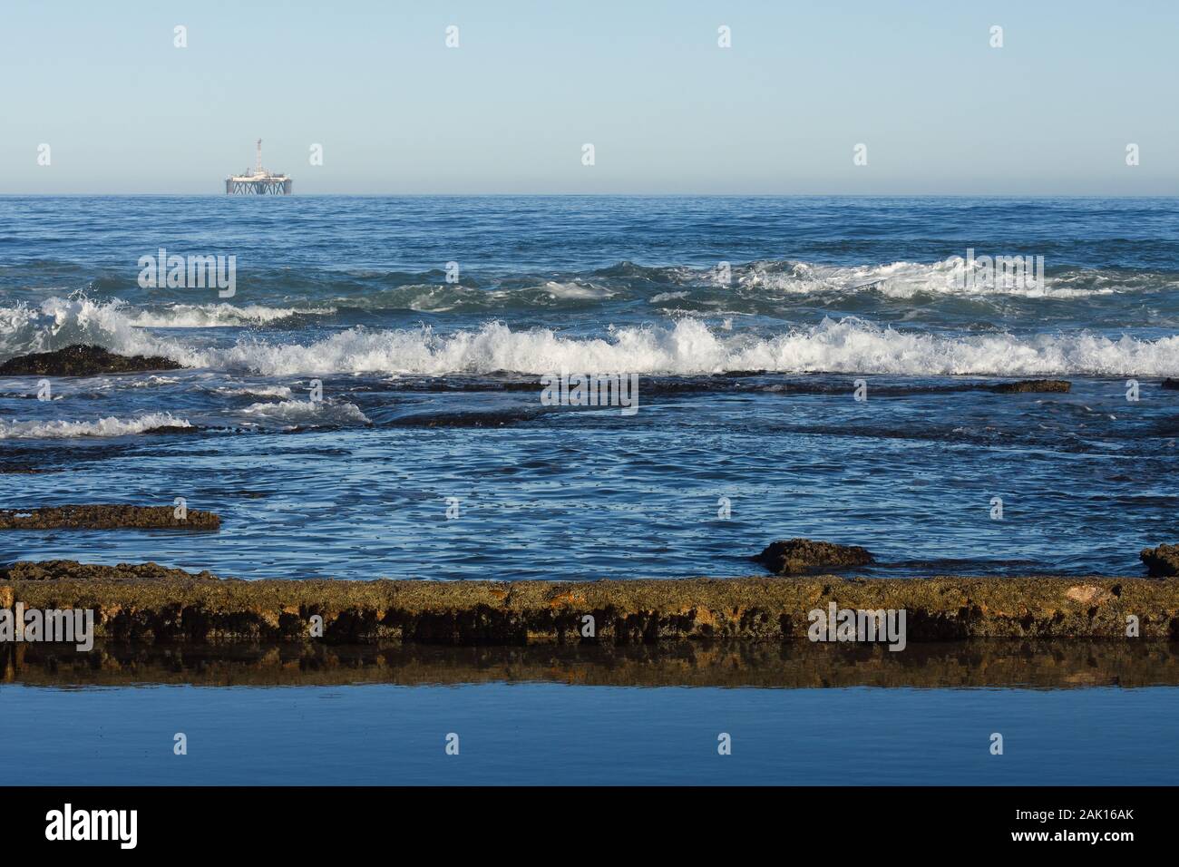 Seashore Tidal Pool And Rocks With Offshore Platform Stock Photo