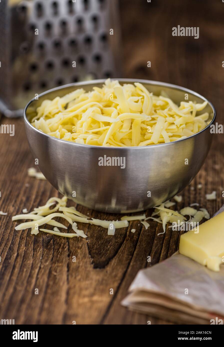 https://c8.alamy.com/comp/2AK16CN/old-wooden-table-with-grated-cheese-close-up-shot-2AK16CN.jpg