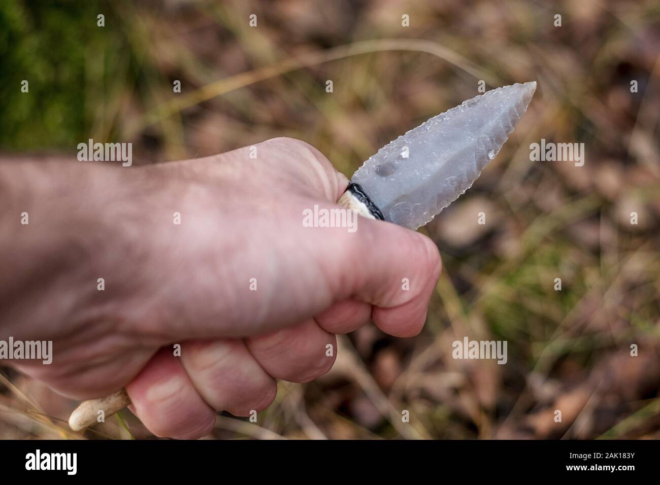 flint knife - stone age tool (leaf blade in deer antler) in hand Stock Photo